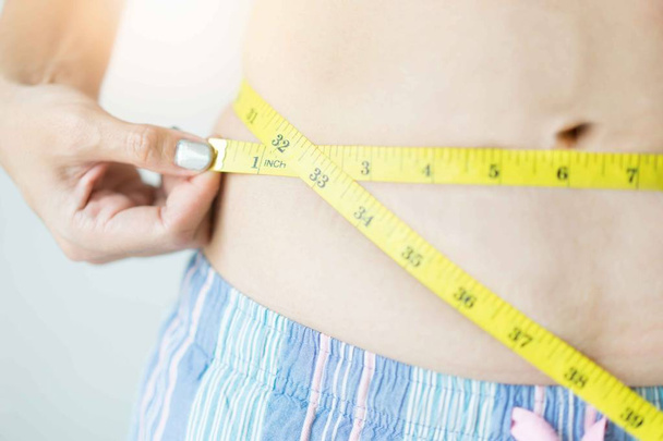 Mulher usar fita métrica para a cintura. Conceito de mulher da dieta
 - Foto, Imagem