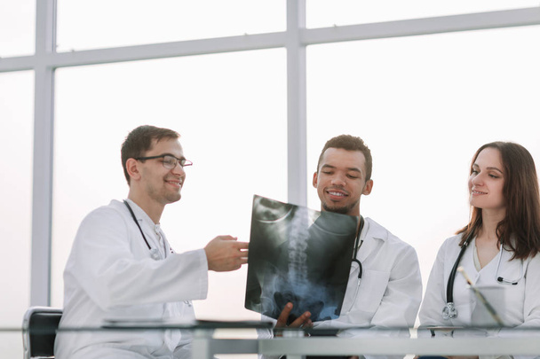 smiling group of doctors discussing the patients x-ray - Фото, изображение