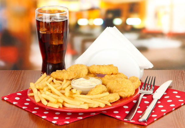 Fried chicken nuggets with french fries,cola and sauce on table in cafe - Фото, зображення
