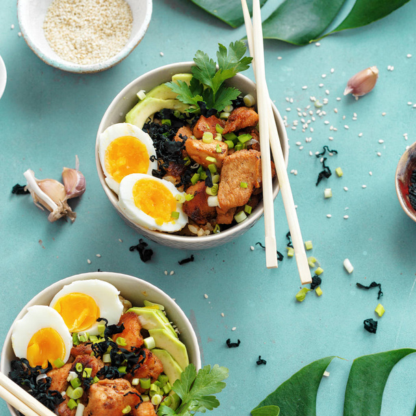 Top view poke bowls of fried rice, chicken fillet and eggs top view. Asian food concept - 写真・画像
