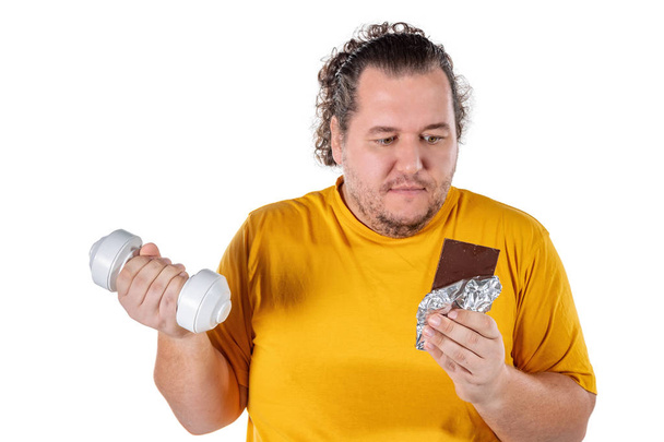 Funny fat man eating unhealthy food and trying to take exercise isolated - Foto, Bild
