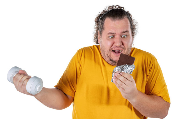 Funny fat man eating unhealthy food and trying to take exercise isolated - Zdjęcie, obraz