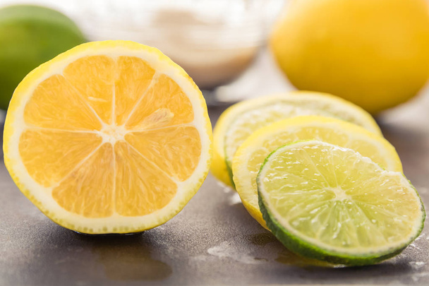 Świeże Plasterki cytryny i limonki są ustawione wzdłuż boku całe i krojone owoce. - Zdjęcie, obraz