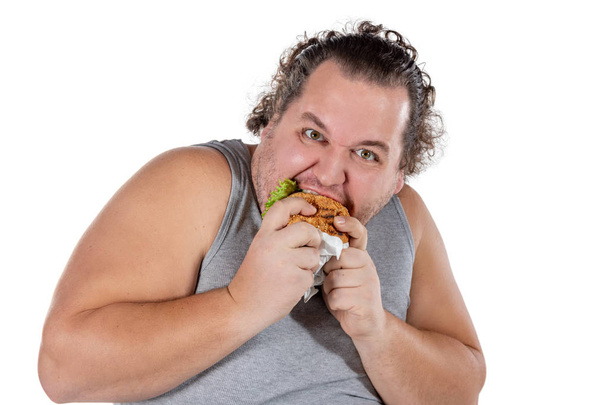 Portrait of funny fat man eating fast food burger isolated - Φωτογραφία, εικόνα