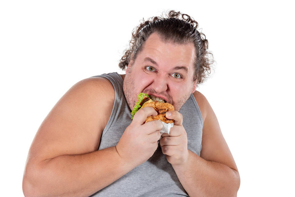 Portrait of funny fat man eating fast food burger isolated - Foto, Bild
