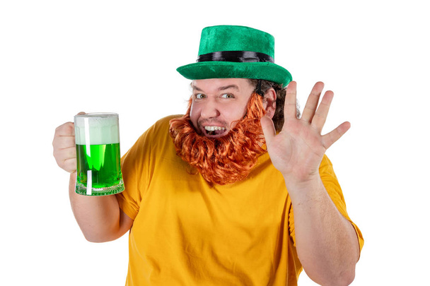 A smiling happy fat man in a leprechaun hat with green beer. He celebrates St. Patrick - Foto, Imagem
