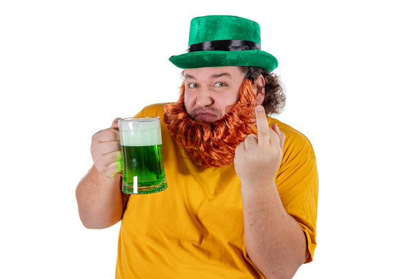 Χαμογελαστά ευτυχισμένος λίπος άνθρωπος σε ένα καπέλο καλλικάτζαρος με πράσινο μπύρα. Αυτός γιορτάζει Αγίου Πατρικίου - Φωτογραφία, εικόνα