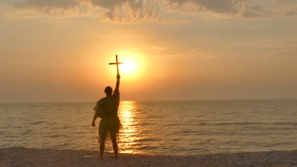 4. christelijke gebed man ascetische monnik met kruis tegen zonsondergang op seacost - Video