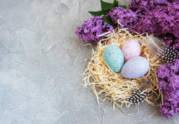 Φωλιά με αυγά του Πάσχα και άνοιξη λιλά λουλούδια - Φωτογραφία, εικόνα