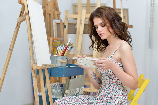 art school, creativity, woman with easel, palette and brush painting at studio - 写真・画像