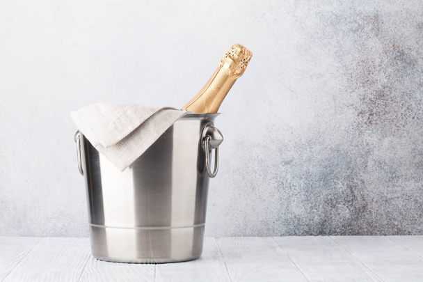 Champagne bottle in bucket in front of stone wall. With space for your text - Zdjęcie, obraz