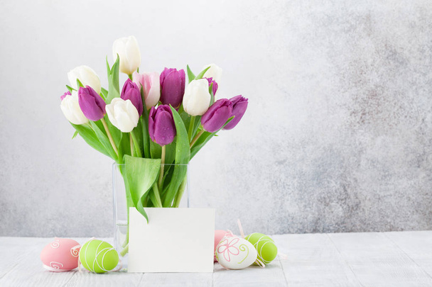 Pasen-wenskaart met tulp bloemen boeket en Pasen eieren. Met ruimte voor uw groeten - Foto, afbeelding