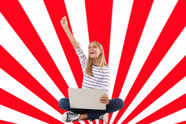 Excited teen girl with laptop sitting on the floor, celebrating success with one arm raised over geometric  background - Foto, Imagem
