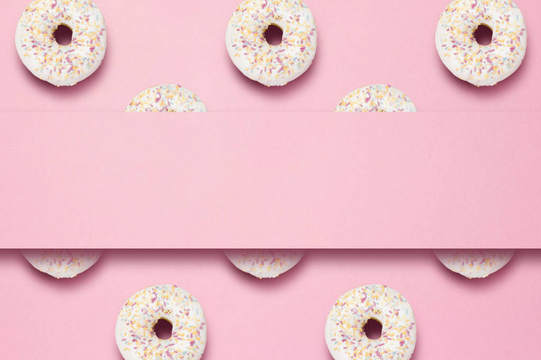 Fresh tasty sweet donuts on a pink background. Place for text. The concept of fast food, bakery, breakfast, sweets. Minimalism. Pattern. Flat lay, top view, copy space - Photo, Image