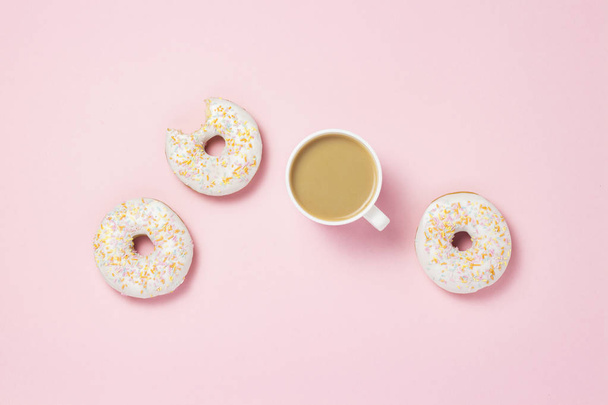 Білий Кубок, кави або чаю з молоком і свіжі смачно солодкий пончики на рожевий фон. Хлібобулочні концепції, свіжу випічку, смачний сніданок, фаст-фуд. Плоскі мирян, top погляд - Фото, зображення