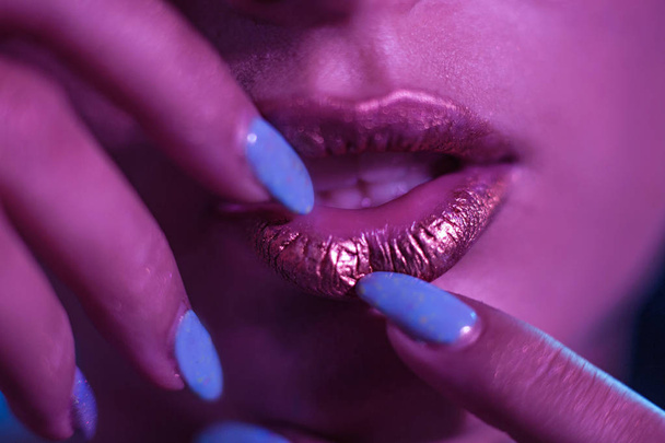 Stylish girl Model with golden lips and bright nails. - Foto, imagen