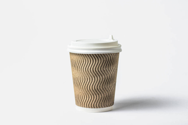 Taza de papel con tapa protectora sobre fondo blanco. Concepto de café o té para llevar, comida rápida, café de la mañana, desayuno
 - Foto, Imagen