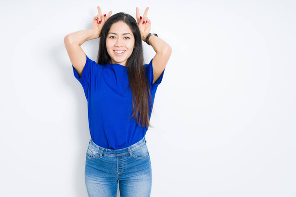 Beautiful brunette woman over isolated background Posing funny and crazy with fingers on head as bunny ears, smiling cheerful - Foto, afbeelding