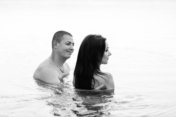 Sunny summer day. Happy couple smiling at the beach - Fotó, kép