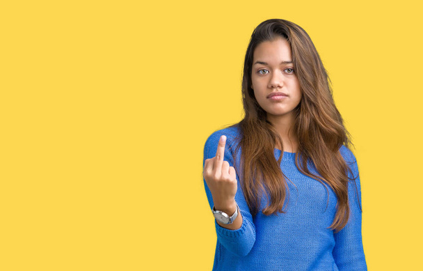 Young beautiful brunette woman wearing blue sweater over isolated background Showing middle finger, impolite and rude fuck off expression - Photo, Image