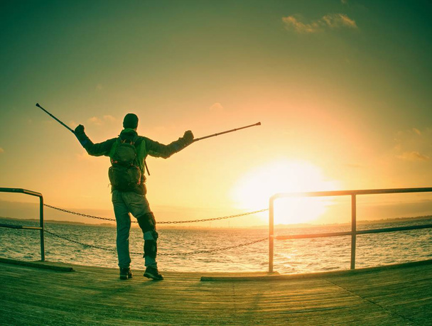 Herir al hombre descansando, mirando a la distancia y meditando. Persona observando la puesta de sol sentada contra el mar azul
  - Foto, Imagen