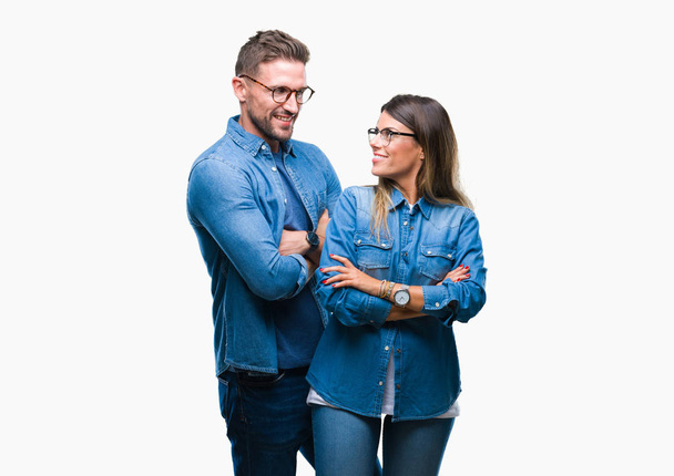 Young couple in love wearing glasses over isolated background happy face smiling with crossed arms looking at the camera. Positive person. - Photo, Image