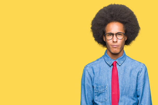 Jonge Afro-Amerikaanse zakenman met afro haar dragen van bril en rode stropdas scepticus en nerveus, fronsen boos vanwege probleem. Negatief persoon. - Foto, afbeelding