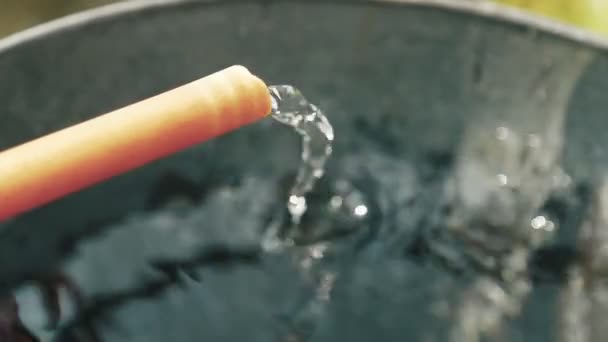 Close-Up de tubo de mangueira de enchimento balde de aço
 - Filmagem, Vídeo