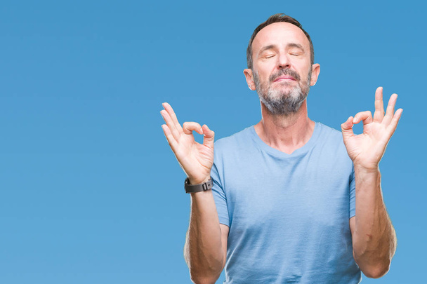 Hoary senior man van middelbare leeftijd op geïsoleerde achtergrond ontspannen en lachend met ogen gesloten doen meditatie gebaar met vingers. Yoga concept. - Foto, afbeelding