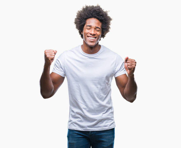 Homem afro-americano sobre fundo isolado animado para o sucesso com armas levantadas celebrando a vitória sorrindo. Conceito de vencedor
. - Foto, Imagem