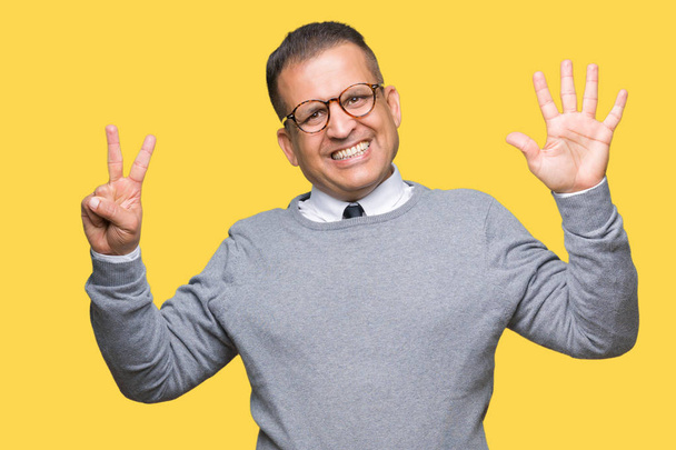Middle age bussines arab man wearing glasses over isolated background showing and pointing up with fingers number seven while smiling confident and happy. - Zdjęcie, obraz
