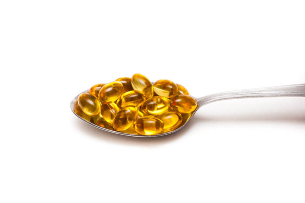 Fish oil in the spoon. Omega-3 pills on spoon. The concept of health care and longevity. - Foto, Bild