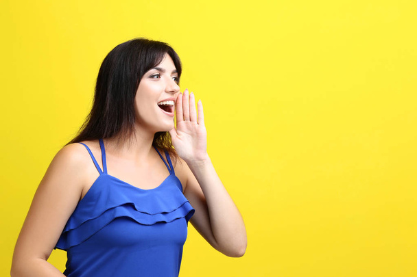 Young woman screaming on yellow background - Fotoğraf, Görsel