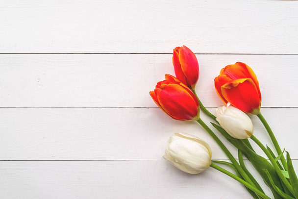 hermosos tulipanes rojos y blancos sobre fondo de madera vista superior
 - Foto, Imagen