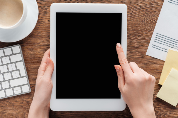 Vue partielle de la femme à l'aide d'une tablette numérique avec écran blanc sur fond en bois
 - Photo, image