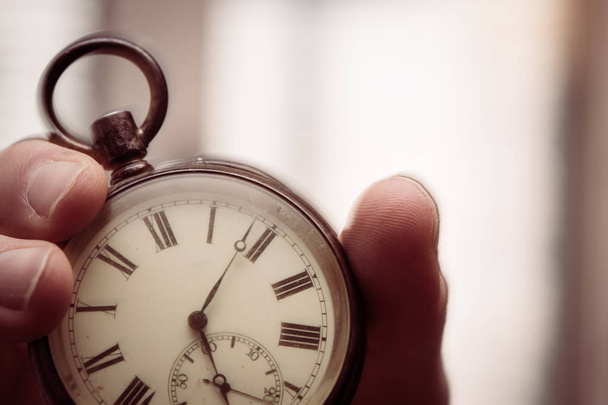 Zeit vergeht: Mann hält Oldtimer-Uhr in der Hand - Foto, Bild