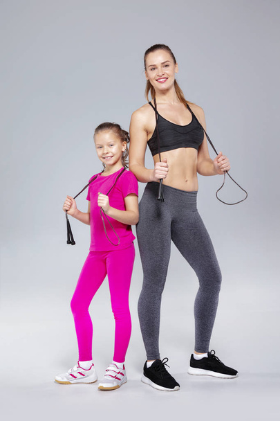 Beautiful woman and her daughter with jumping rope - Valokuva, kuva