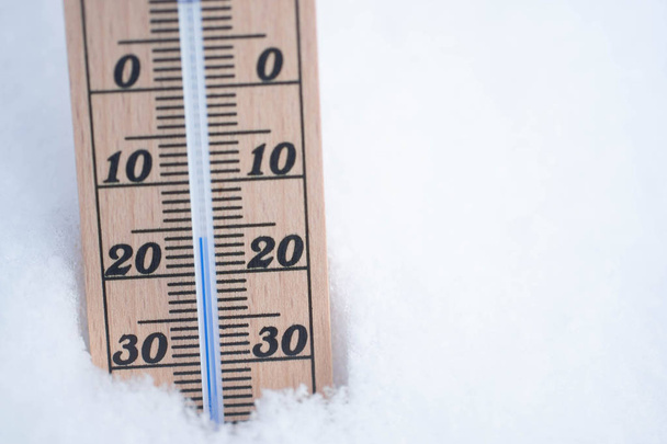 wooden thermometer in snow with freezing temperature copy space - Photo, Image