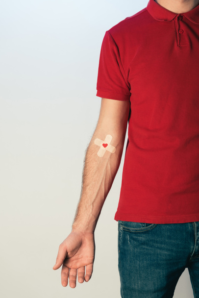 Partial view of patient in red t-shirt with plasters, blood donation concept - Photo, Image