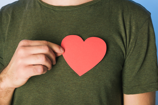 Yeşil t-shirt erkekte görünümünü kesilmiş kağıt kalp tutan - Fotoğraf, Görsel