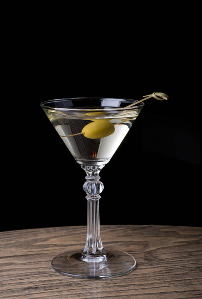 Martini glass with olive on a bar counter - Valokuva, kuva