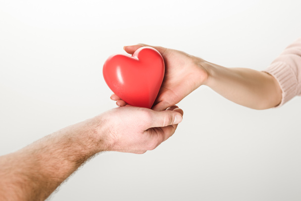 Partial view of man and woman holding toy heart on white background - Photo, image