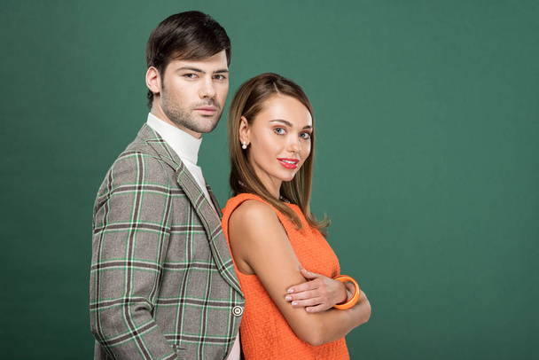beautiful couple in vintage clothes posing and looking at camera isolated on green with copy space - Foto, immagini