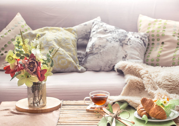 Interior acolhedor caseiro primavera na sala de estar com um vaso e flores café da manhã caseiro, conceito de conforto em casa
 - Foto, Imagem