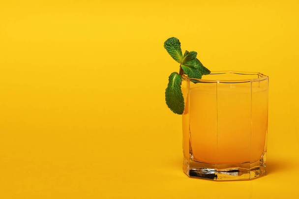 orange juice in a glass on a yellow background - Zdjęcie, obraz