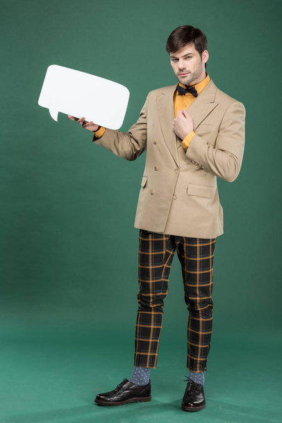 handsome man in vintage clothes holding speech bubble on green background - Фото, зображення