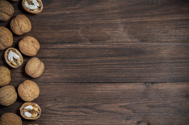 Walnuts lie on a wooden background with a place for copy space - 写真・画像