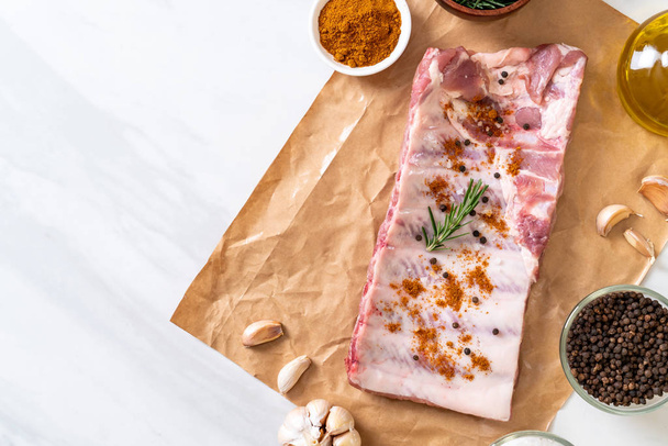 Fresh raw pork ribs ready for roasting with ingredients - Foto, afbeelding
