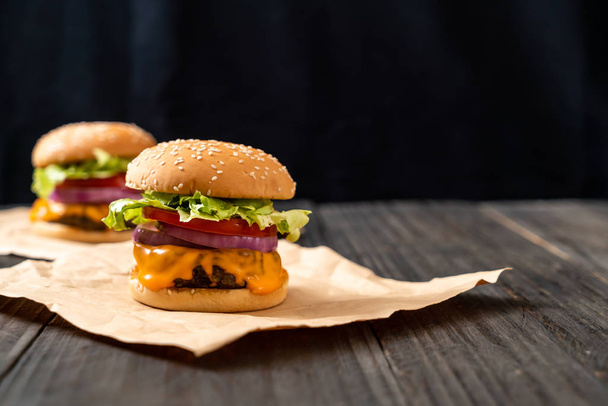 friss, ízletes marha burger, sajttal és sült krumpli a fa háttér - Fotó, kép