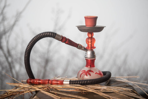 Cold shisha concept. Hookah, traditional arabic waterpipe outdoor photo. Cold winter background. Empty space. Selective focus - Photo, Image